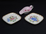 PORCELANA, três (3) itens: 1 cinzeiro no formato de pá, ornamentação floral policromada sobre fundo rosa, arremates com frisos dourados, medindo 15,5 cm comprimento; 2 (par) covilhetes quadrangulares, manufatura P.II RJ (D. PEDRO II, Rio de Janeiro, RJ, fundada em 1921 por Tinoco Machado, Industrial Carioca, que contava com auxiliares que vieram da tradicional Fábrica de Vista Alegre de Portugal, foi a primeira fábrica de porcelana autêntica em escala Industrial no Brasil, funcionou até a década de 80), pintados a mão em policromia pelo atelier XAVIER, medindo 13 x 13 cm, generosos arremates a ouro.