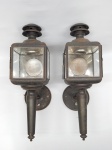 LUMINÁRIAS, par (2) arandelas para um lume, tipo lanterna, vidros bisotados, confeccionadas em folha de flandres, ligeiros sinais de oxidação, falta um vidro de uma delas, parte elétrica não testada, sinais de uso, medindo 41 cm altura.