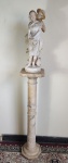 ESCULTURA, assinatura não identificada, uma (1) representando menina sendo cortejada por menino em alabastro, sinais de restauro, acompanha coluna em mármore branco rajado, com fuste cilíndrico com anéis alternados, base terminando em placa octogonal, capitel quadrangular com quinas chanfradas. Assinada. Alt. da escultura 52cm, da coluna 100cm.
