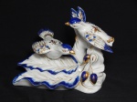 PORCELANA, uma (1) escultura representando pássaros pousados em um galho, tonalidade branca com detalhes em azul e dourado, apliques facetados coloridos em vidro ou símile, medindo 19 x 17 x 15 cm.