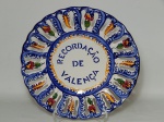 FAIANÇA ALCOBAÇA, Portugal, um (1) medalhão na tonalidade branca com típica decoração em azul e flores policromadas, pintado à mão, borda vazada, com a inscrição RECORDAÇÃO DE VALENÇA (Valença, também chamada Valença do Minho, é uma cidade praiana portuguesa do Distrito de Viana do Castelo, com 2000 anos e aventuras históricas de Portugal e Espanha),  medindo 30 cm diâmetro.