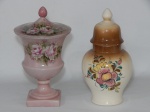 PORCELANA, dois (2) vasos com tampa distintos, ambos com ornamentação floral policromada pintada a mão: 1 bojudo e 1 de pé alto no estilo Médici, com fuste quebrado e colado.
