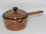 VIDRO, uma (1) panela com tampa e cabo longo, marca CORNING, linha VISION, Made in USA, capacidade 1 litro, tonalidade âmbar translúcido, íntegra, pouco uso, marcado PIREX na tampa, medindo 16 cm diâmetro.