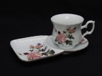 PORCELANA, uma (1) xícara para chá, pires com aba extensora, ligeiramente canelada da própria modelagem, ornada com rosas e borboletas, arremates com frisos dourados, marca DM BRASIL, medindo o pires 20,5 x 12,5 cm, peça para coleção de cristaleira.