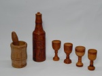 MADEIRA, seis (6) itens torneados: conjunto 1 garrafa e 4 cálices; 1 pilão com soquete, medindo a maior peça 22 cm altura, usados.
