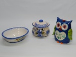 FAIANÇA, três (3) itens: 1 cofre no formato de coruja policromada da Trevisan Concept, medindo 18 m altura; 1 terrina na tonalidade branca com detalhes em azul e floral policromado, medindo 21 x 17 cm, com bicado, sem marca de manufatura aparente; 1 pote de alho com tampa e desenho floral nas tonalidades azul e verde, medindo 13 cm altura e 13,5 cm diâmetro.