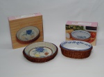 PORCELANA E VIME, duas (2) assadeiras em porcelana na tonalidade branca acompanhadas de cesto em vime, decoradas com motivos de frutas e legumes policromados sendo: 1 redonda, medindo 20 cm diâmetro e 1 oval, medindo 17 x 11 cm, ambas Made in China.