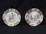 PORCELANA CHINESA, dois (2) pratos decorativos pintados a mão: 1 com ornamentação central representando a Deusa Kuan Yin (Deusa da Misericórdia e Compaixão), próxima a uma criança, borda com elementos vegetalistas, arremates a ouro; 1 com cena do gênero representando duas mulheres pintando, borda com flores e pássaros, arremates a ouro, ambos com marca de origem em legenda e caracteres e medindo 15,5 cm diâmetro.