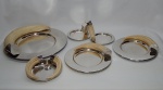 METAL PRATEADO, conjunto com cinco (5) itens, todos com apliques imitando presas de javali, da manufatura DUE SORELLE: 1 travessa circular, medindo 37 cm diâmetro; 2 (par) pratos medindo 24,5 cm diâmetro; 1 covilhete com dois pratos unidos, medindo 30,5 x 15 cm; 1 covilhete com duas presas, medindo 17 cm diâmetro.