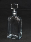 CRISTAL SUECO, uma (1) garrafa retangular translúcida com tonalidade levemente azulada, assinatura ilegível no fundo, medindo 27 cm  altura; usada, tampa com bicado.