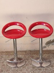 MOBILIÁRIO, par (2) banquetas para bancada de bar ou cozinha americana, design contemporâneo, assento moldado na tonalidade vermelha, base metálica cromada, com suporte para apoio dos pés e regulagem de altura, sinais de uso e oxidação. Alt. 80cm.
