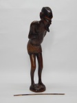 ARTE TRIBAL AFRICANA, uma (1) escultura representando guerreiro de pé segurando uma lança (quebrada), entalhada em madeira maciça, possui rachados, medindo 33 cm altura.