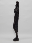 ARTE TRIBAL AFRICANA, uma (1) escultura representando mulher de vestido carregando bolsa, com a mão na altura do seio, medindo 35 cm altura.