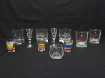 CRISTAL E VIDRO, onze (11) copos e taças, incolores e translúcidas para drinks, modelos variados, a maioria com propaganda esmaltada de bebidas e remédios, usados.