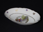 PORCELANA, uma (1) travessa oval com borda alta, medindo 28 x 20 x 6 cm, ornamentação com cena do gênero em policromia sobre fundo branco, borda com flores intercaladas policromadas e douradas, arremates a ouro, manufatura REAL (Mauá, SP, 1943 a 1994), usada.