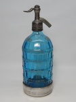 DIVERSOS, uma (1) antiga garrafa sifonada, marca SODA SAN BERNARDO, Indústria Argentina, Buenos Aires, confeccionada em vidro moldado em geométricos na tonalidade azul translúcido, fundo com proteção em alumínio, medindo 30 cm diâmetro.