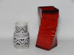 FAIANÇA E CERÂMICA, dois (2) vasos floreiros: 1 modelado em geométricos, representando placas quadrangulares empilhadas e desencontradas, tonalidade vermelha, extremidades em degrade, fundo com forração em feltro, medindo 23,5 cm altura; 1 cilíndrico com degrau próximo a boca, ornado nas tonalidades preta e branca, inspirado no padrão Marajoara, medindo 15,5 cm altura.