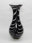 MURANO, um (1) imponente vaso floreiro no formato de balaustre, confeccionado em vidro soprado, incolor e translúcido, com sulfitos internos mesclados nas tonalidades preta e branca, medindo 44 cm altura.