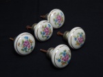DIVERSOS, cinco (5) antigas maçanetas, confeccionadas em porcelana com ornamentação floral policromada, arremates com frisos dourados, medindo 4,5 cm diâmetro.