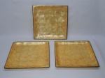 DIVERSOS, três (3) travessas quadrangulares, ligeiramente abauladas, confeccionados em polímero com texturização nacarada, medindo 30,5 x 30,5 cm, borda em metal dourado.