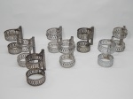 METAL PRATEADO, oito (8) suportes com alça em gradil vazado, canelado e perolado, para copo, confeccionados em folha de flandres, medindo 10,5 cm altura, diâmetro interno 6,9 cm na parte de cima e 6,5 cm na parte de baixo.