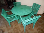 Mesa redonda e 4 cadeiras em madeira ripada pintada de verde. Centro com furo para guarda-sol. Marcas de uso.  Mesa Alt. 70 x Diam. 100cm.