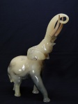 ESCULTURA, uma (1) representando elefante, confeccionada em resina marmorizada, presas em polímero na tonalidade marfim, sem marca de manufatura aparente, medindo 40 cm altura.