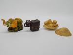 ESCULTURAS, três (3) representando elefante: 1 antiga confeccionada em celulose, tonalidade marfim, formato de concha bivalve, medindo 8 x 7,5 cm; 1 em cerâmica policromada, tonalidades verde, amarela e branca, medindo 12 cm; 1 em resina com tampa, policromado, predominância da tonalidade marrom, pequenos defeitos, medindo 8 cm.