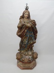 ARTE SACRA, uma (1) imaginária de Nossa Senhora da Conceição, encontra-se de pé com as mãos em posição de oração, mãos quebradas e coladas, três anjos na base, confeccionada em estuque policromado com falhas na policromia, medindo 62 cm altura.
