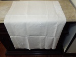 Toalha de linho bege bordada em crivo com flores e folhas. Manchas de guardado. 240 x 125cm.