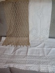 Três  panos de mesa: a) Caminho de mesa em crochet marrom. 166 x 36cm. b) Caminho de mesa em linho com bordado nas pontas. 130 x 60cm. c) Caminho de mesa em algodão e rendado nas pontas. 130 x 85cm. Com manchas.