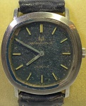 UNIVERSAL (Geneve) - Elegante e raro relógio de pulso suíço, a corda, com caixa em aço e pulseira em couro. Med 3,5 cm. Obs: No estado.
