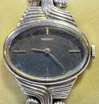 SEIKO - Elegante e antigo relógio de pulso japonês, modelo feminino, no estilo art deco, a corda, com caixa e pulseira em aço finamente cinzelado. Funcionando no momento. Med 2,5 cm.