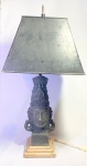 ARTE ORIENTAL - Antiga e rara luminária de mesa tailandesa, para duas lâmpadas, circa 1940, em pedra patinada esculpida a mão, representando Cabeça de Divindade. Apoiada sobre base em mármore. Med 80x38x38 cm.