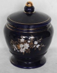 Potiche confeccionado em porcelana mas cor azul índigo decorado com flores brancas e lilás com folhagens e filetes a ouro, apresenta rachado no bojo conforme foto -  med. 25cm alt. x 16 cm diam.