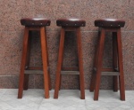 Lote com 3 linda banquetas antigas de madeira nobre e pesados, denominadas de bar, pé alto, assento revestido com couro marrom e toda tacheado nas bordas. alt. 87cm