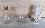 Lote com cinzeiro de grosso vidro moldado, antigo perfumeiro de vidro no formato de lâmpada  com 15cm de altura e uma pequena ânfora de biscuit branco com desenhos em relevo de homem alimentando a ave com 15cm de altura.