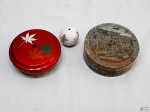 Lote composto de 2 caixas decorativas e 1 enfeite de bola em porcelana. Sendo uma das caixas em laca e uma em pedra decorada. Medindo a caixa em pedra 12,5cm de diâmetro x 4,5cm de altura