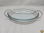 Travessa oval funda em vidro temperado com suporte em metal prateado. Medindo a travessa 35cm x 24cm x 6cm de altura.