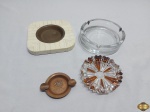 Lote de 4 cinzeiros, sendo 2 em vidro, 1 em cobre e 1 em lâmina de osso. Medindo o maior em vidro 14cm de diâmetro x 4cm de altura.