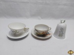 Lote de 2 xícaras de chá e sino sineta de mesa em porcelana diversa. Medindo o sino 11cm de altura.