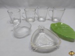 Lote composto de 4 canecas em vidro e 3 petisqueiras em vidro. Medindo a petisqueira na forma de folha 15,5cm x 12,5cm x 2,5cm de altura.