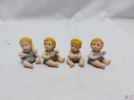 Jogo de 4 enfeites na forma de bebe sentado em resina. Medindo o maior 5,5cm de altura.