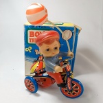 BRINQUEDO ANTIGO de LATA (Releitura) - Triciclo de lata com Menino em borracha segurando um balão de plástico (BOYS TRICYCLE), fabricado na China. Na caixa original. Funciona a corda. Mede aproximadamente 11cm de comprimento.