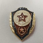 4. Militária. Distintivo de qualificação das Forças Armadas (Exército Vermelho) da URSS com estrela vermelha e imagem de foice e martelo. Muito Bem Conservado. Produzida nos anos 80, a peça traz a marca do fabricante no verso. Sem Circulação. Mede 30 x 40 mm.