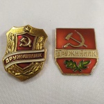 5. Militária. (2) Belos Distintivos da POLÍCIA VOLUNTÁRIA DA URSS, com imagem de foice e martelo. As peças trazem a marca do fabricante no verso.