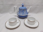 Lote composto de bule em porcelana azul floral e 2 xícaras de chá em porcelana Renner com friso prata. Medindo o bule 15cm de altura.