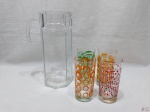 Jogo de 4 copos longos em vidro com estampa colorida e jarra em vidro facetado incolor. Medindo os copos 14cm de altura e a jarra 26,5cm de altura.