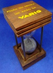 MAGNÍFICA AMPULHETA - BRINDE PROMOCIONAL DA " V A R I G " TRAZ AS INSCRIÇÕES: POUSA OU DECOLA UM AVIÃO DA VARIG EM CADA OITO MINUTOS ... FABRICADA EM VIDRO , COM BASE EM MADEIRA E HASTES EM METAL ... PEÇA COM 10,0 cm