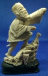 PEQUENA ESCULTURA ORIENTAL EM MARFIM ( ORIGINAL ) DIMENSÃO 8,7 x 5,2 cm APRESENTA ALGUNS DESGASTES DO TEMPO, COMO BRAÇO LEVANTADO COLADO E FALTA O CHAPÉU PESO BRUTO COM A BASE EM MADEIRA 44,6 g